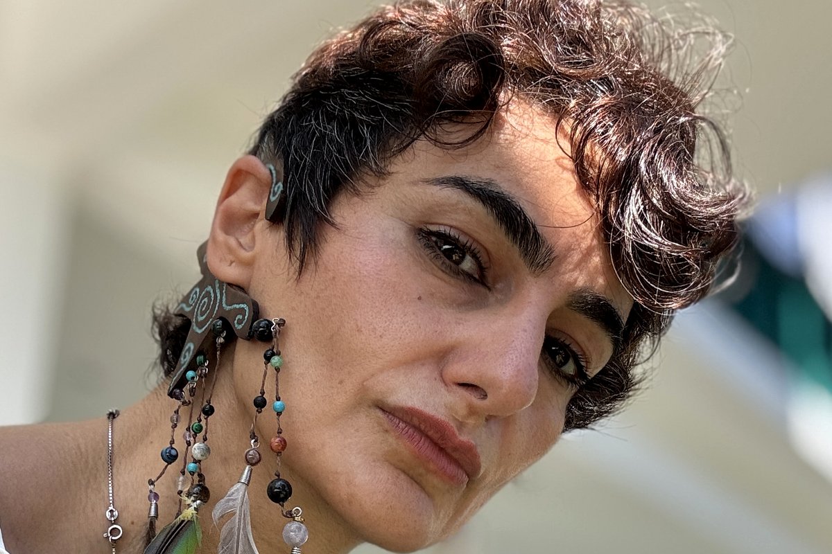 Dr. Pariya Kashfi, portrait with feather earrings